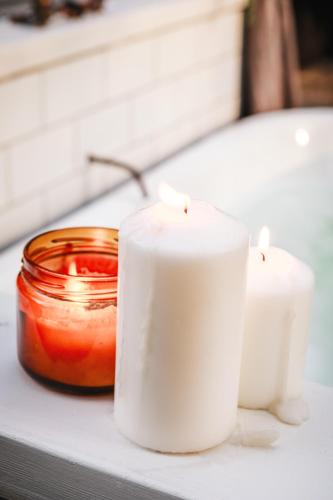two white candles sitting on a counter next to a jar at Birdsong Bellingen Farm in Thora