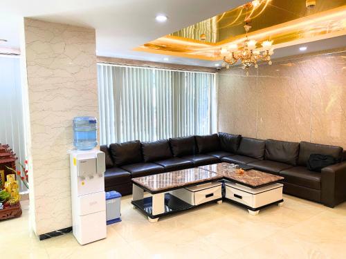 a living room with a black leather couch and a water cooler at Khách sạn Hồ Giám in Hanoi