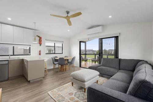 a living room with a couch and a kitchen at Swan Bay Holiday Park in Queenscliff