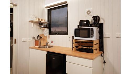 a kitchen with a counter top with a microwave at Kings Cottage by Tiny Away in Irymple