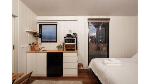 a bedroom with a bed and a desk with a microwave at Kings Cottage by Tiny Away in Irymple