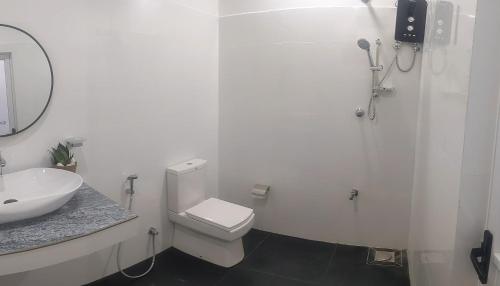 un bagno bianco con un water e un lavandino di Cealora Resort a Dambulla
