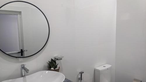 a white bathroom with a mirror and a sink at Cealora Resort in Dambulla