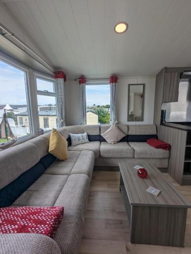 a living room with a couch and a table at Pet-Free Swift Burgundy Family Holiday Home at Littlesea Holiday Park, Weymouth in Wyke Regis