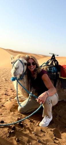 a woman posing with a camel in the desert at Sahara Luxury Camp VIP in Merzouga