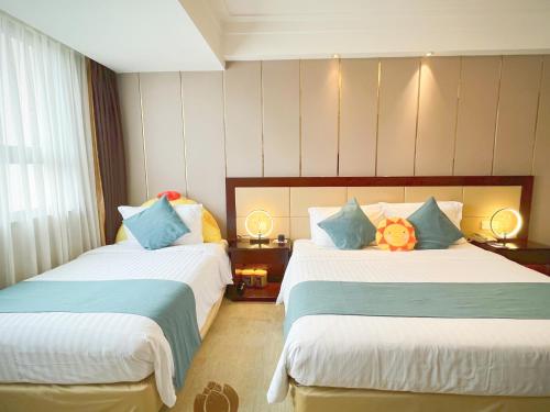 a hotel room with two beds with pillows at Jin Jiang West Capital International Hotel the Bell and Drum Tower Muslim quarter & Metro Line 6 & indoor swimming pool & self-service free laundry room in Xi'an