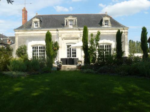 une grande maison blanche avec une pelouse devant elle dans l'établissement La Grouas, à Vauchrétien