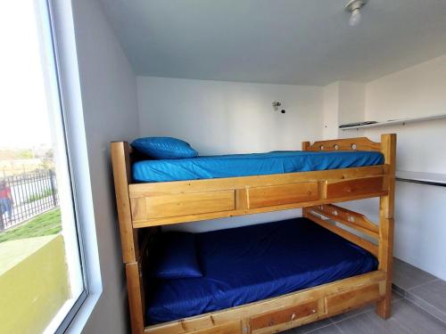 two bunk beds in a small room with a window at Bonito Aparatemnto con Piscina in Santa Marta
