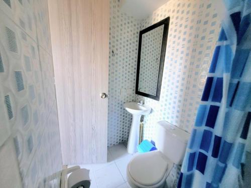 a bathroom with a toilet and a sink and a mirror at Bonito Aparatemnto con Piscina in Santa Marta