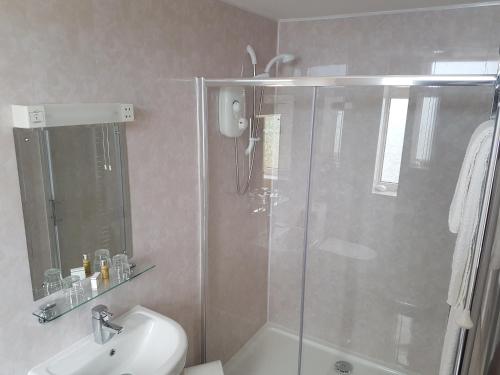 
a bathroom with a shower, sink, and toilet at Halfway House Hotel in Larne
