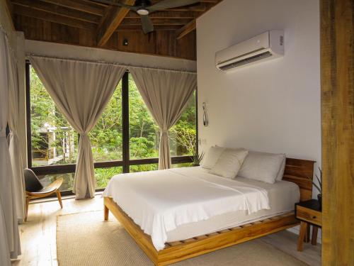 a bedroom with a bed and a large window at Villa con piscina privada, West Bay Roatan in Coxen Hole