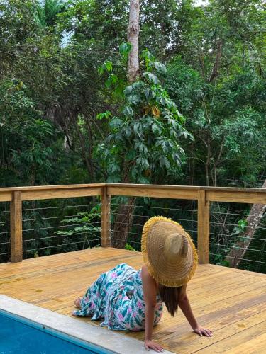 a girl in a hat laying on a deck next to a pool at Villa con piscina privada, West Bay Roatan in Coxen Hole