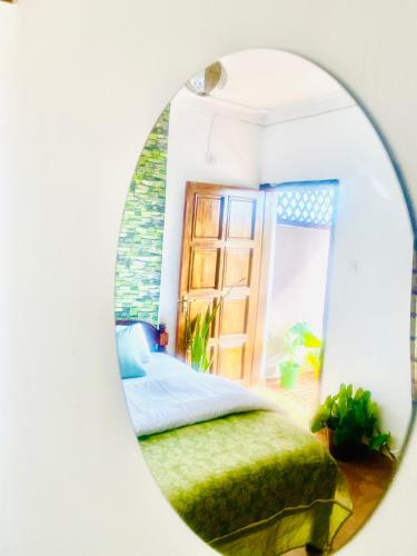 a bedroom with a bed and a mirror at Shikos Place in Watamu