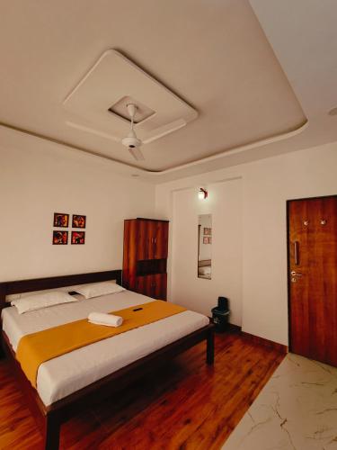 a bedroom with a large bed with a ceiling at Shiv Shakti in Alibaug