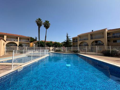 une grande piscine devant un immeuble dans l'établissement T2 RDC à Canet en Roussillon Europa 4 pers ,piscine,clim, tennis, parking, à Canet