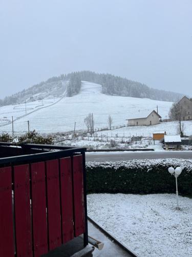 a snow covered field with a road in the distance at Hôtel Au Feu De Bois in Autrans