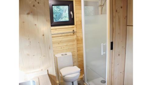 a small bathroom with a toilet and a window at Vilasini Hut by Tiny Away in Great Horkesley