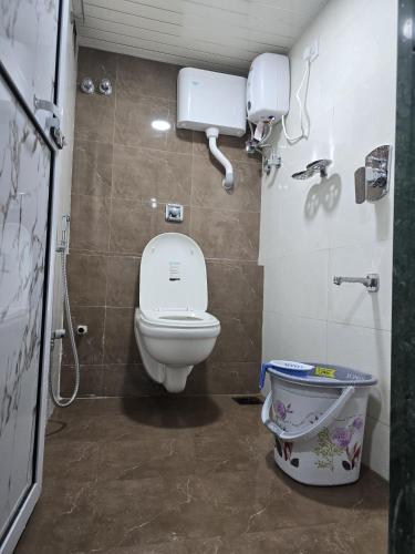 a small bathroom with a toilet and a shower at Aqua Marol Dormitory in Mumbai