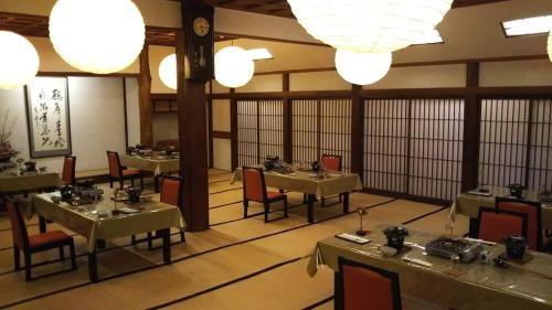 厚木市にあるTamagawakan元湯玉川館のテーブルと椅子と照明のあるダイニングルーム
