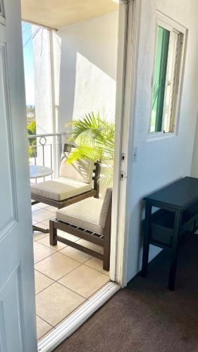 a door to a balcony with a table and a bench at Complete cozy apartment in Playas in Tijuana