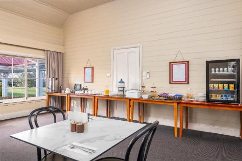 a room with a table and chairs and a counter at Moore Park Inn in Armidale