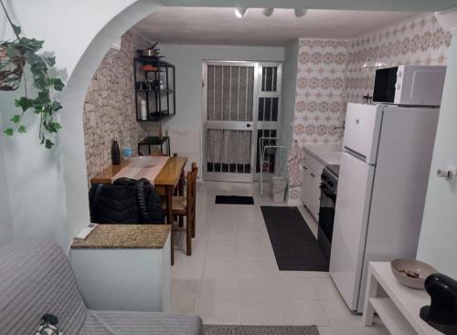 a kitchen with a table and a white refrigerator at Luce di Stagno in Stagno