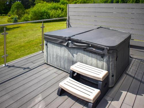 una barbacoa en una terraza con un banco en Oak Park Two - Uk50063, en Tiverton