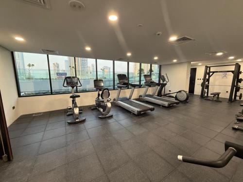 a gym with several treadmills and elliptical machines at 1 Bedroom in Maryah Island by Central Stay 1 min to Cleveland, Galleria Mall and ADGM in Abu Dhabi