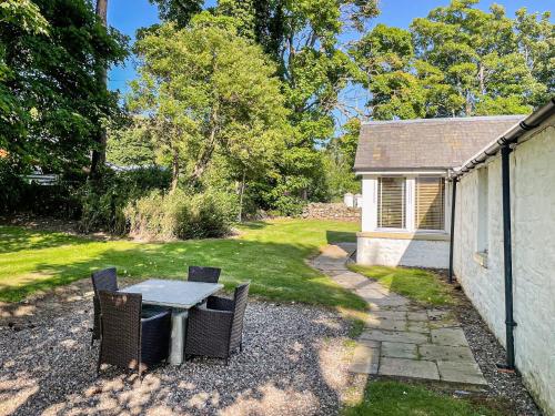 a patio with a table and chairs in a yard at Brandy Cottage - Ukc6855 in Millton of Clova