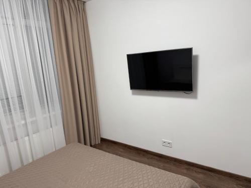 a flat screen tv on a white wall in a bedroom at VIP Apartments 9 in Odesa