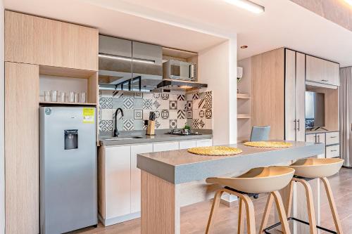 a kitchen with a refrigerator and a counter with stools at Edificio Habitare Cristales Cali 2 in Cali