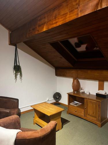 a living room with a couch and a table at Hôtel Au Feu De Bois in Autrans
