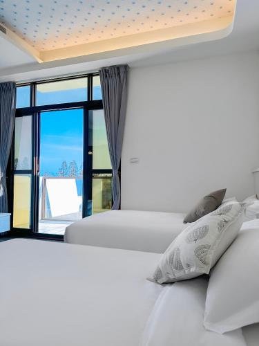 a bedroom with two beds and a window at Long Xing B&B in Huxi