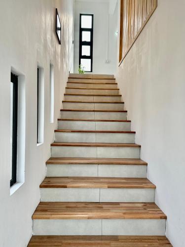a staircase in a house with white walls and wooden floors at Lotus D`Or Villa in Trou aux Biches