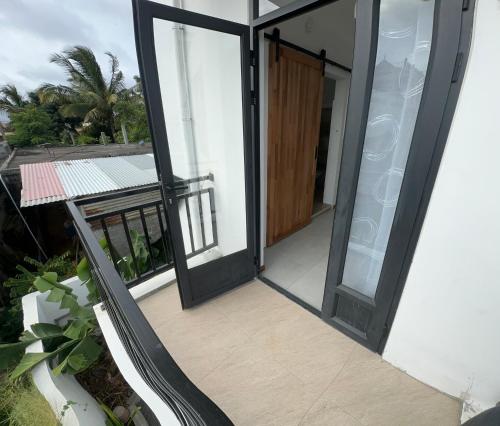 an open door of a house with a balcony at Lotus D`Or Villa in Trou aux Biches