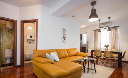 uma sala de estar com um sofá e uma sala de jantar em Suite Celebration em Split
