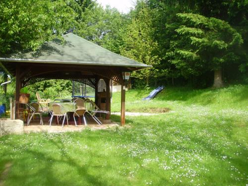 a gazebo with a table and chairs in a field at Tavi Vendégház in Szentgotthárd