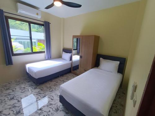 Una pequeña habitación con dos camas y una ventana. en Cosy Chill, en Ko Pha Ngan