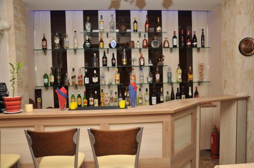 a bar with a lot of bottles of alcohol at Denis Hotel and Bungalows in Korinós