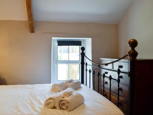 a bedroom with a bed with towels on it at Troedyrhiw Isaf in Tregaron