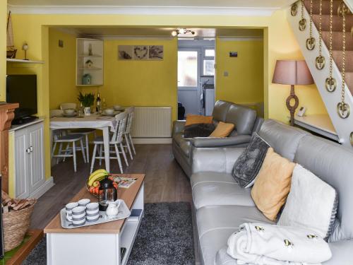 a living room with a couch and a table at Selkie Cottage in Corton