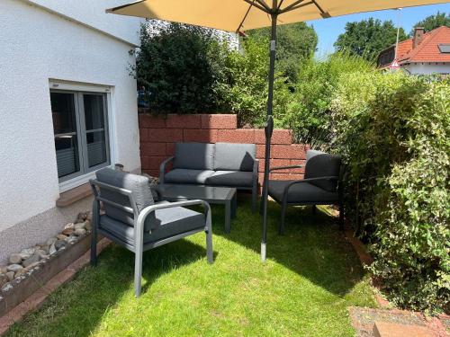 two chairs and an umbrella in the grass at Fernblick in Zweibrücken