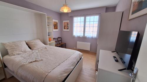 une chambre avec un lit et une télévision à écran plat dans l'établissement Grande maison 4 chambres 5 lits Les Sables d'Olonne, à Les Sables-dʼOlonne