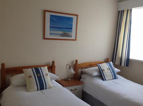 a bedroom with two beds and a picture on the wall at Copper Beech Rooms in Newquay