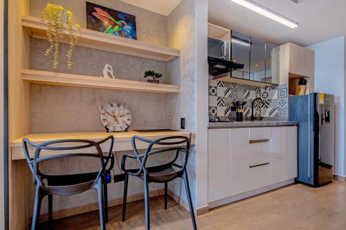 a kitchen with a counter and two chairs at a table at Edificio Habitare Cristales Cali 2 in Cali