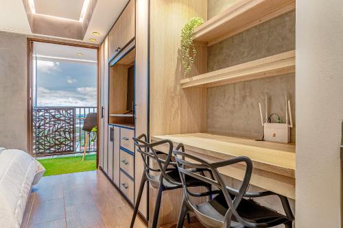 a bedroom with a desk with two chairs and a window at Edificio Habitare Cristales Cali 2 in Cali