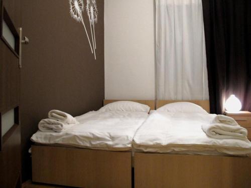 Cama en habitación con sábanas y almohadas blancas en University Apartments, en Cracovia