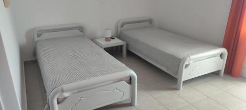 two beds in a small room with a table at Filina's Studio in Maltezana