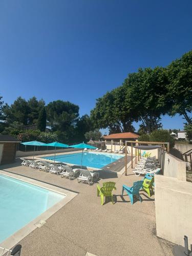 une piscine avec des chaises longues et une piscine dans l'établissement Camping Le Pre Saint-Andre, à Souvignargues