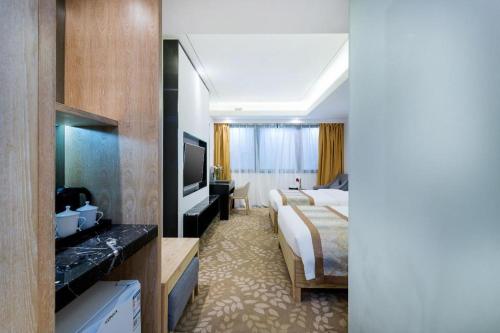 a hotel room with a bed and a television at Golden Central Hotel Shenzhen in Shenzhen
